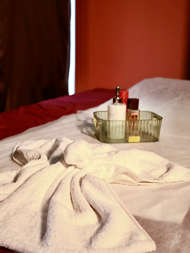 Fresh white towel and massage oils laid out on a massage bed at Artham Luxury Spa, Andheri West