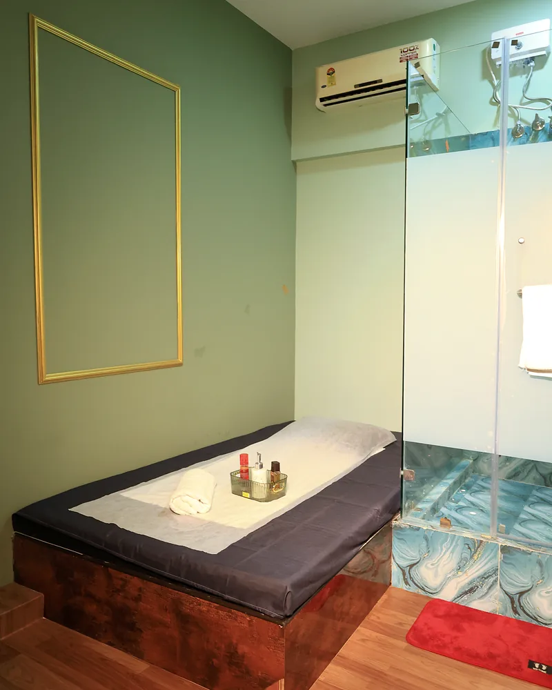 Private massage room at Artham Luxury Spa with a massage bed, a fresh towel and a glass shower cubicle