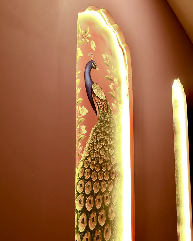 Peacock artwork panel with warm edge lighting on a wall at Artham Luxury Spa, Andheri West