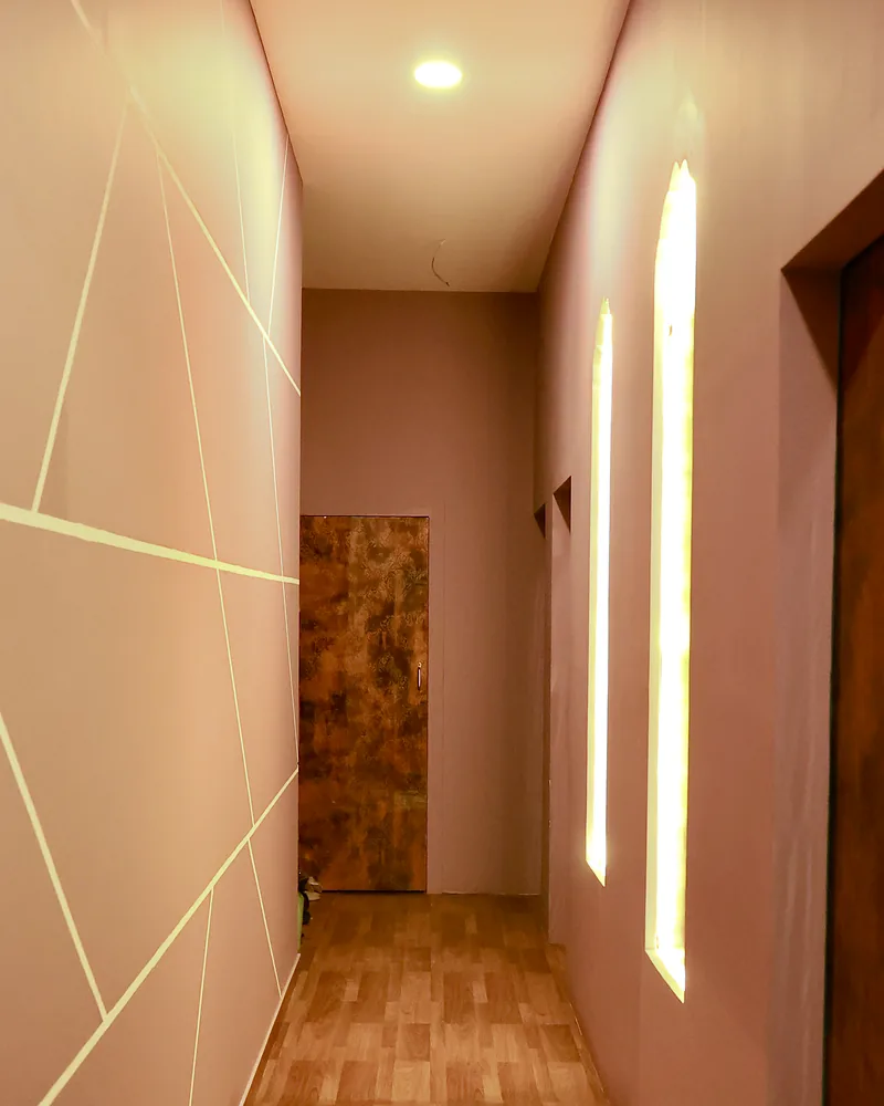 Softly lit corridor with wooden flooring and lit wall niches at Artham Luxury Spa, Andheri West